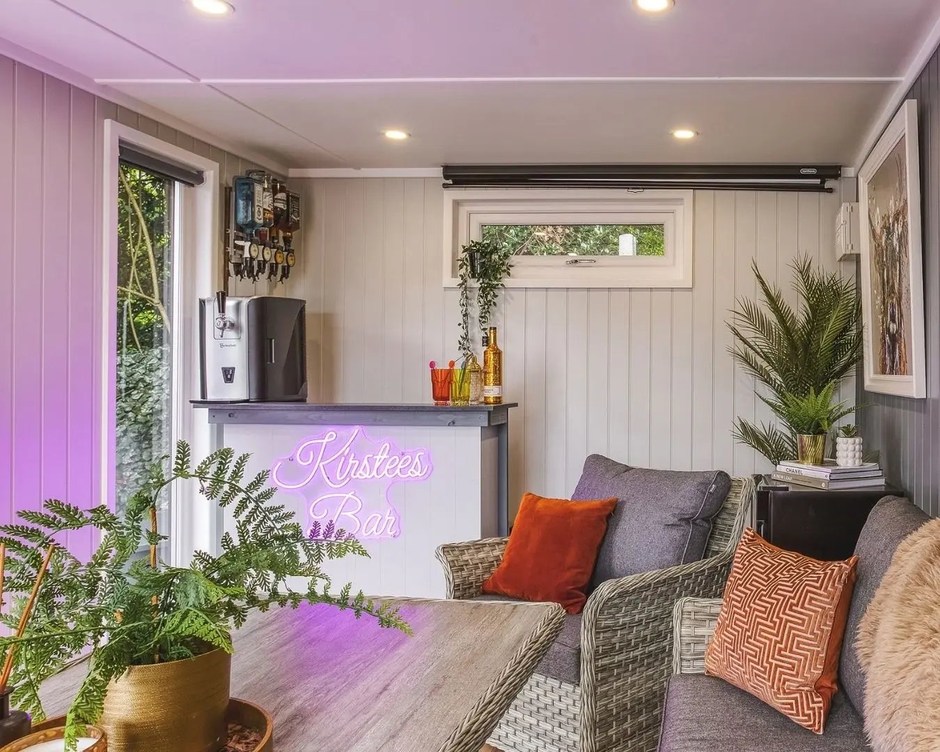 Cosy garden room dining area with corner sofa seating, wooden table, and soft furnishings in a modern interior