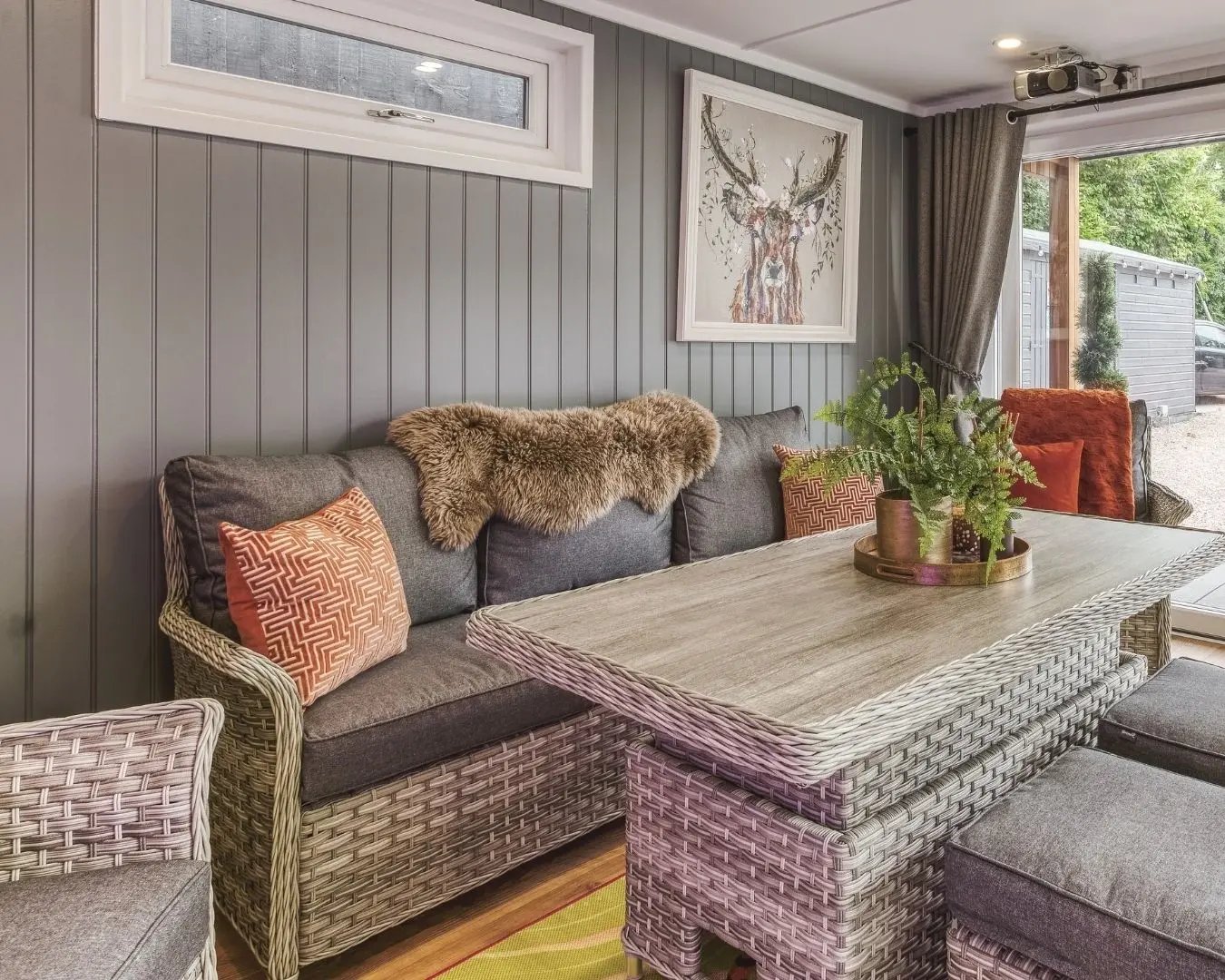 Garden room bar interior with drinks station, neon sign, and comfortable seating for entertaining at home