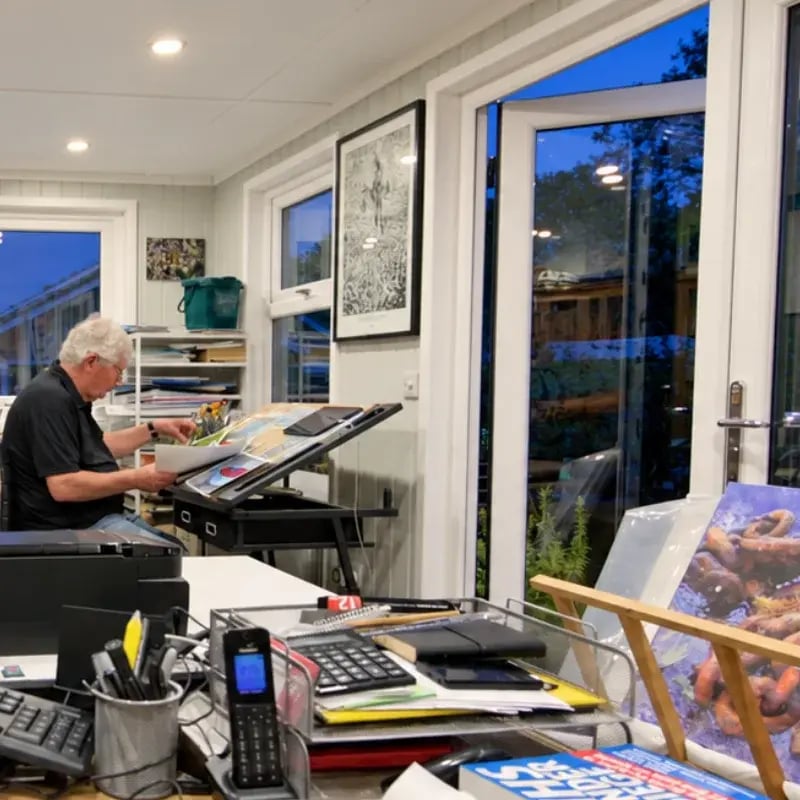 man painting in his garden art studio