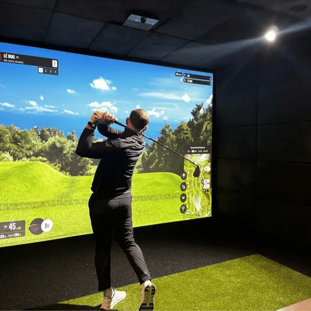 man playing golf inside golf sim