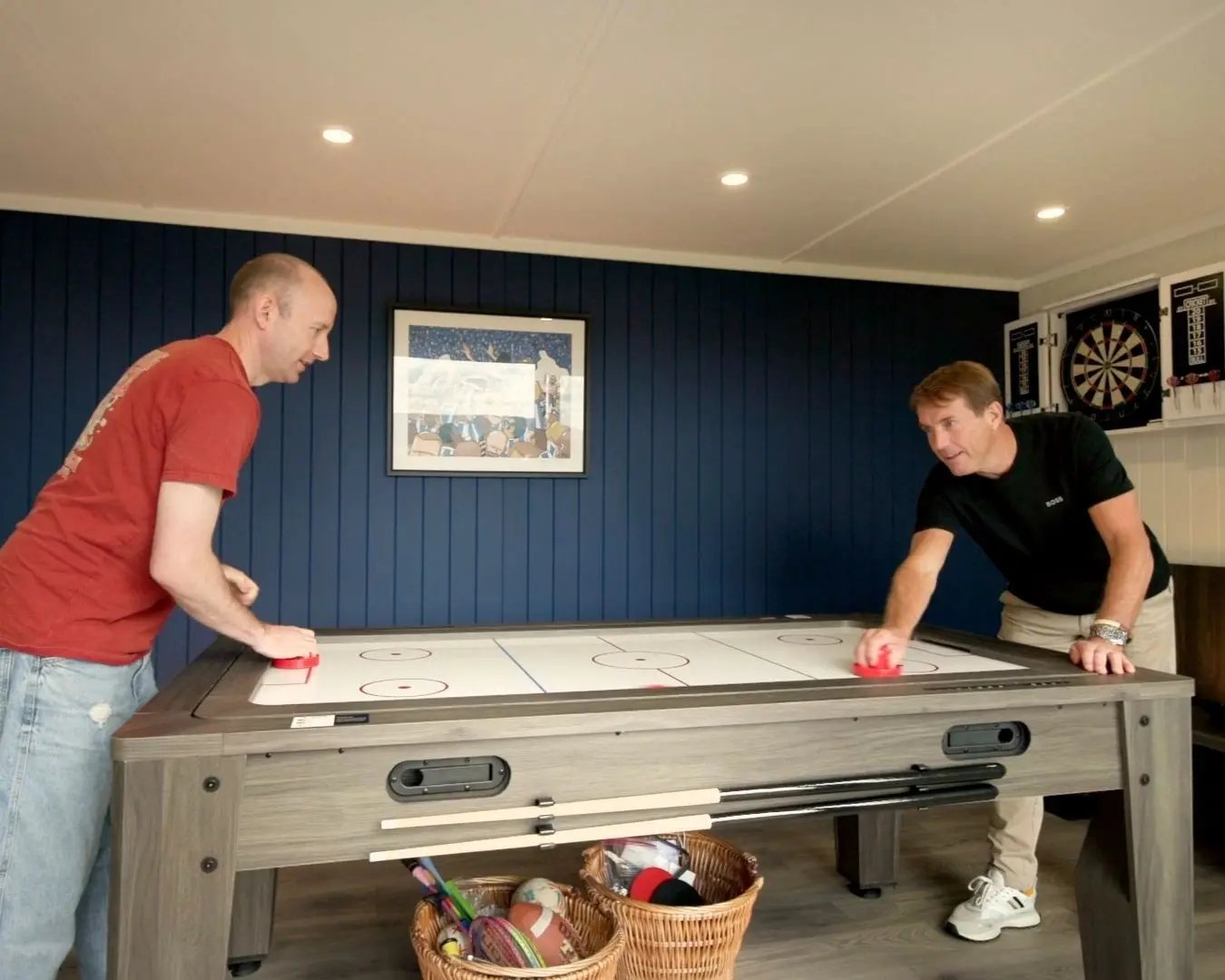 two people playing air hockey inside a garden cabin
