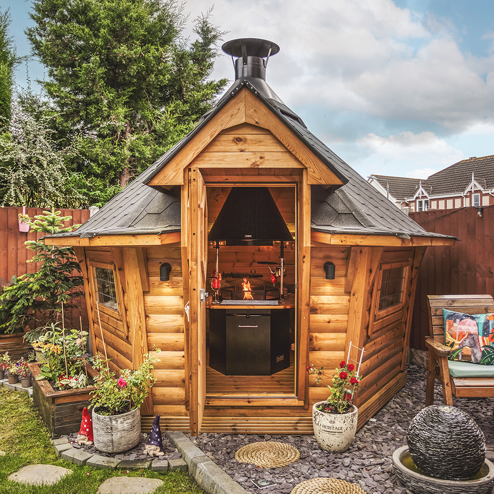 Grill cabin in small urban garden with door open so bbq unit can be seen
