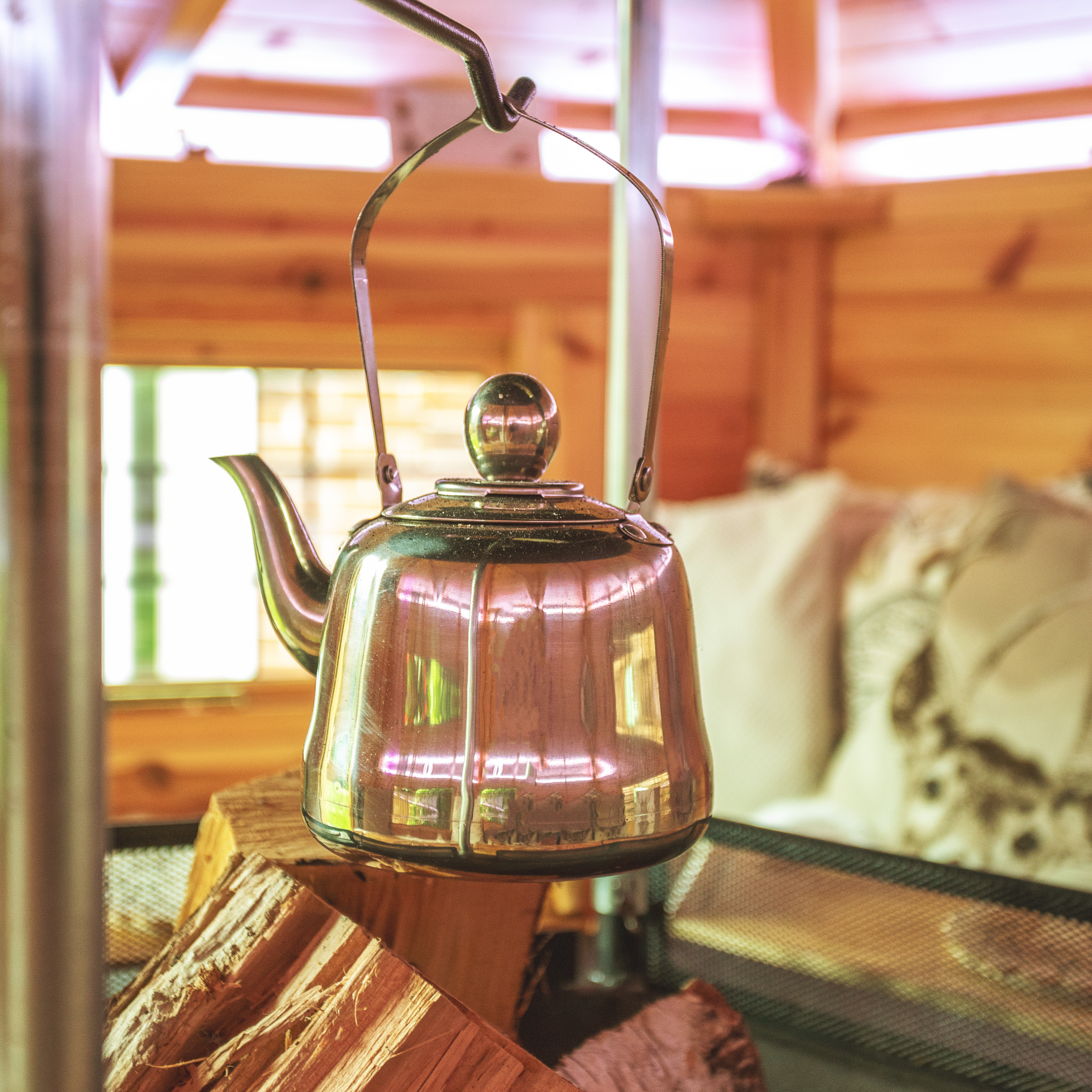 mulled wine kettle hanging over logs in a bbq hut
