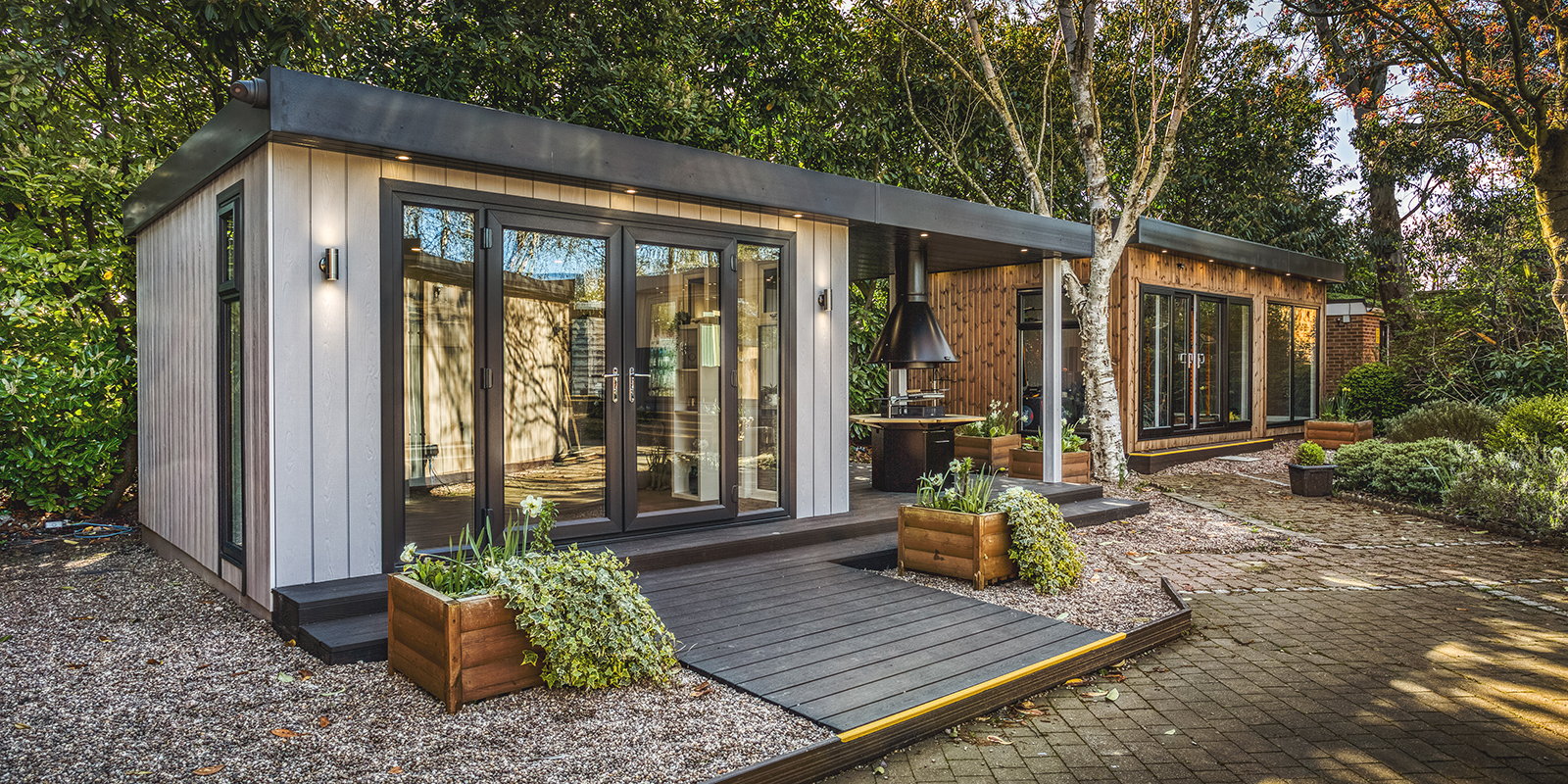 Large zero maintenance garden room with veranda and integrated BBQ unit with seating