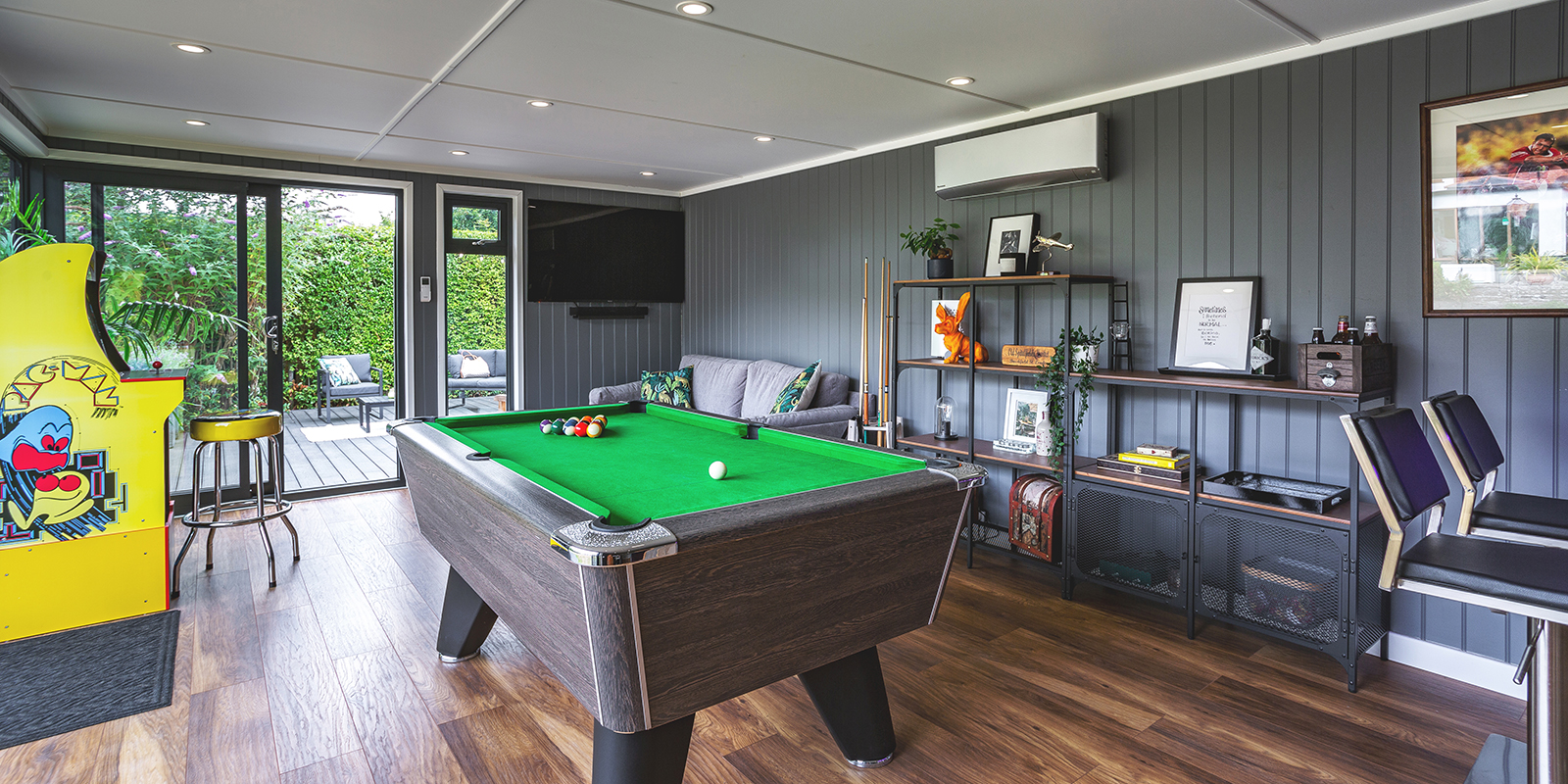Interior of a garden bar games room for entertaining, with pool table and seating 