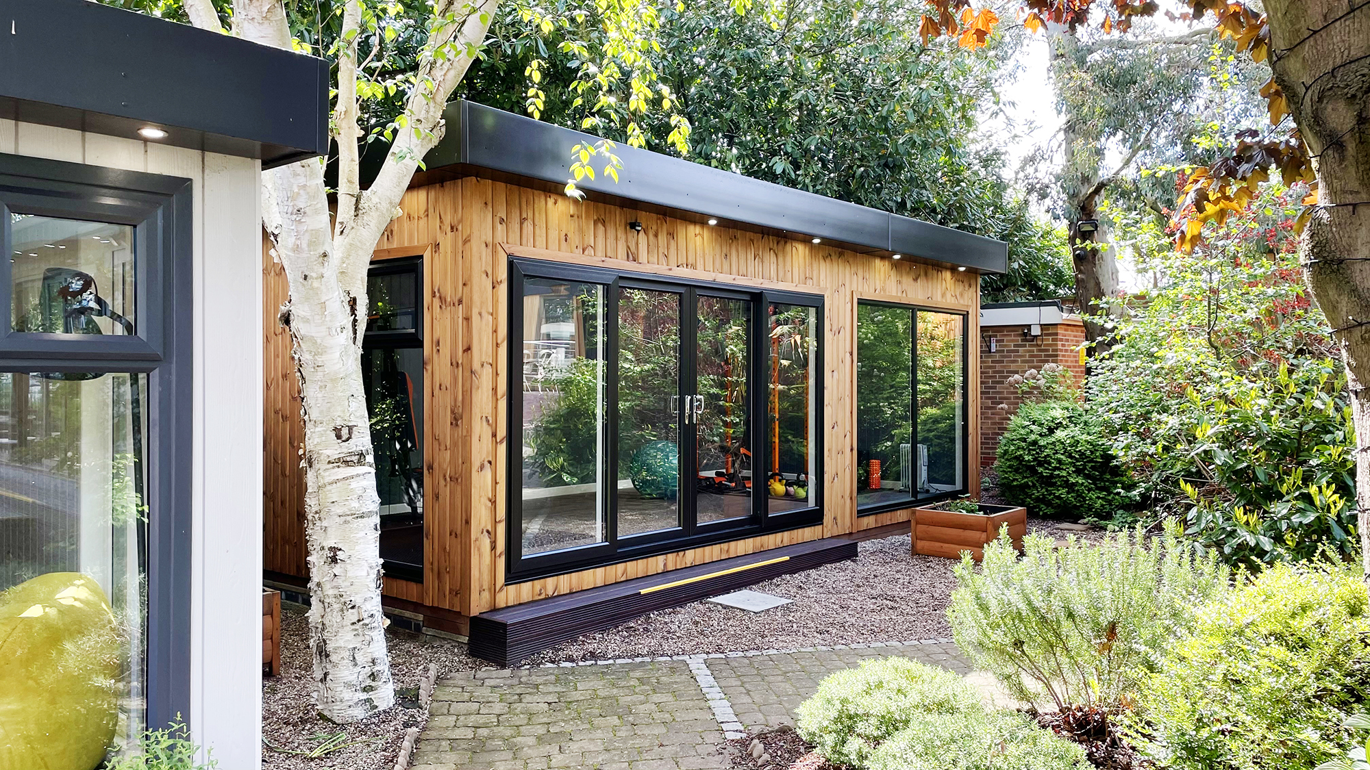 Exterior hot of an extra tall Garden Room Gym in redwood 