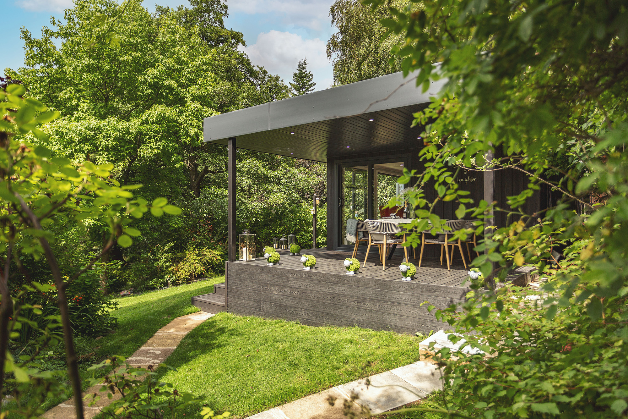 Exterior of a black zero maintenance garden room with veranda