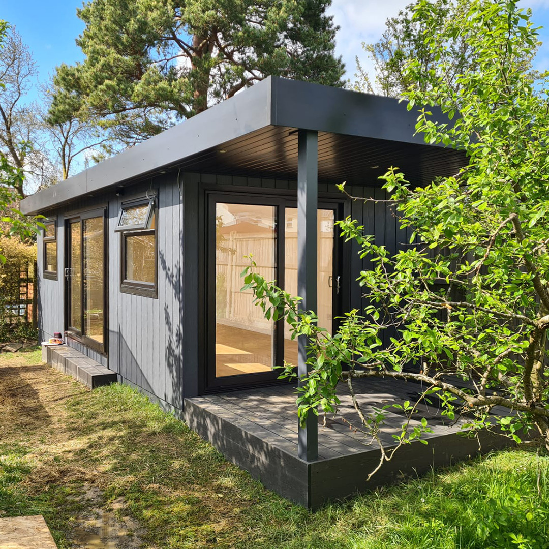 Marley Board Garden Room with large veranda in lawn area with small tree in front of it 