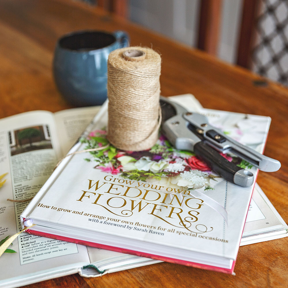 garden room with sunflowers in a vase on top of table with books and twine