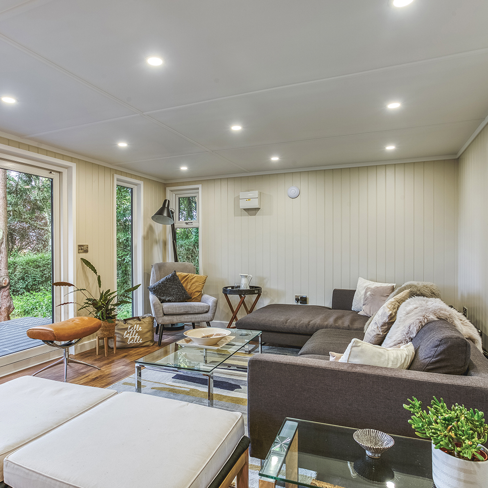 internal view of garden music room with sofas and leather footstool