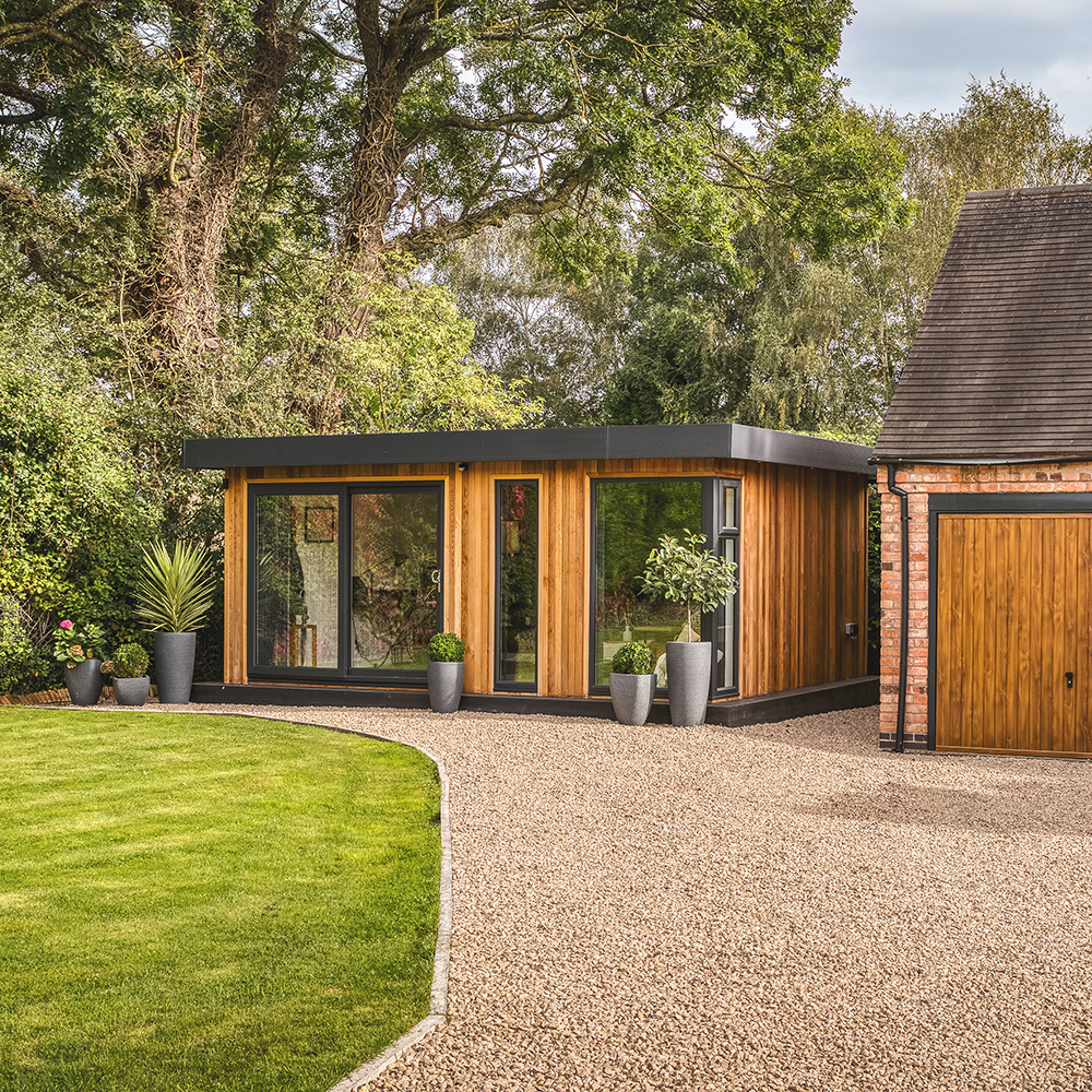 Exterior of a medium sized garden office pod at bottom of gravel path