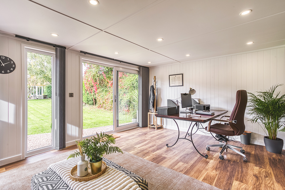 Office pod interior with desk set up & garden views