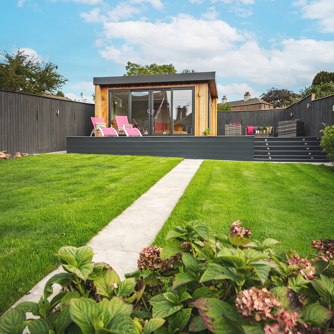 Garden summerhouse on raised decking at bottom of garden