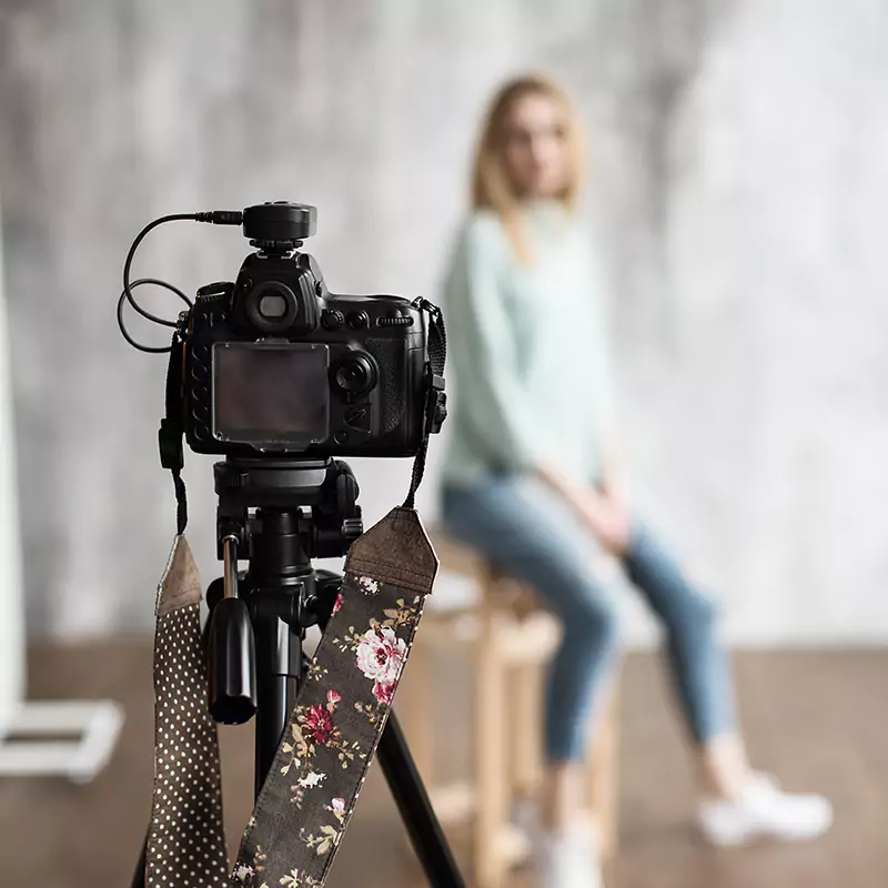 woman posing behind camera out of focus during photoshoot