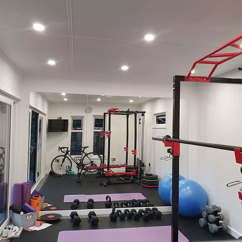 Inside Garden Gym with Squat Rack Bench Press and Large Mat Area with Dumbbells and Bike