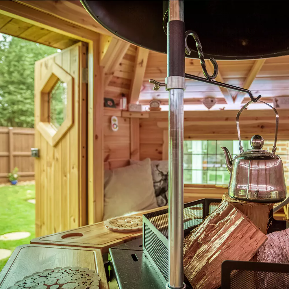 inside a BBQ hut looking out of door into garden