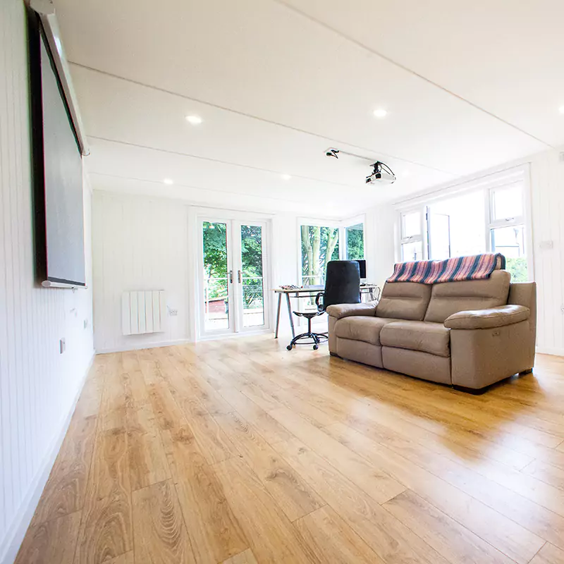 a garden cinema room filled with furniture and a hard wood floor 