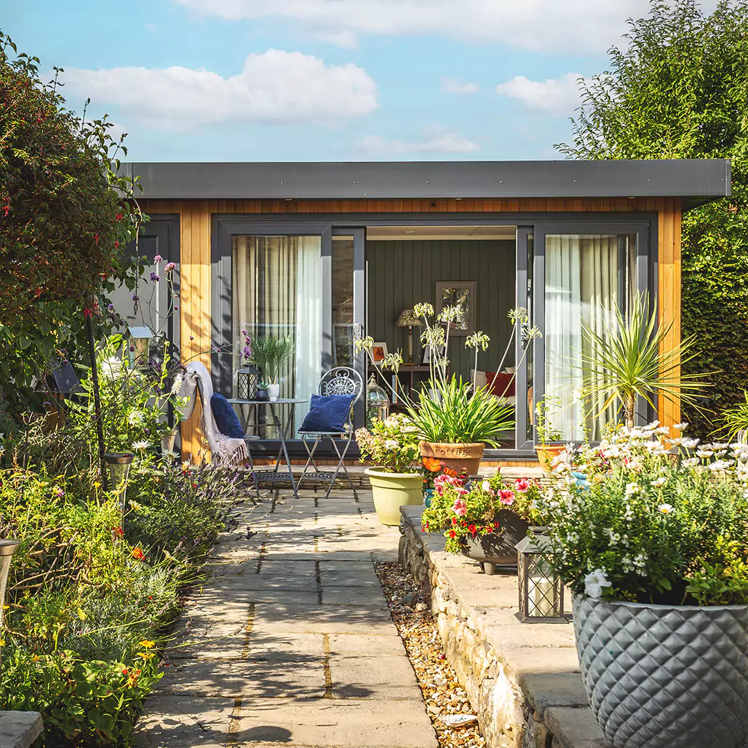 Cedar clad garden room shoffice in sunny garden