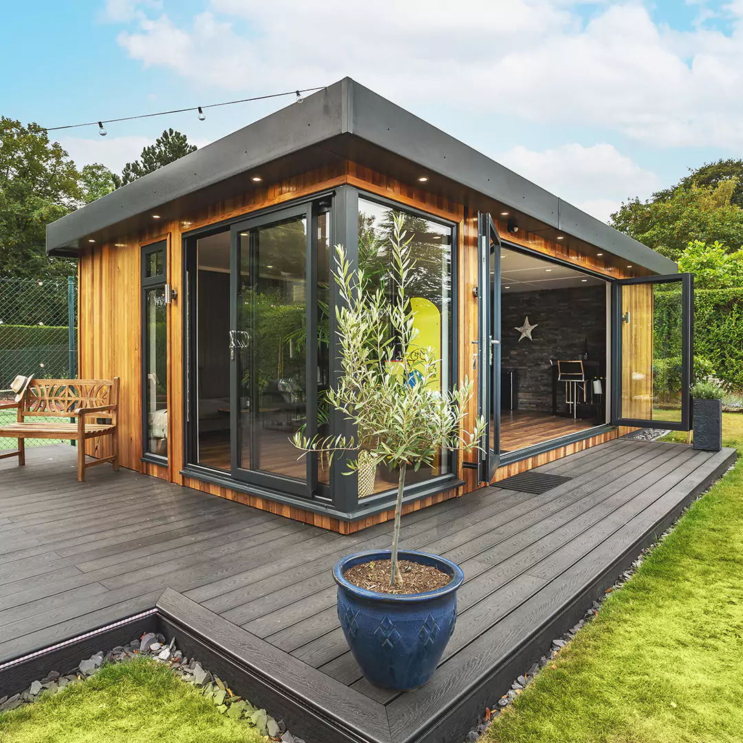 Cedar garden bar on large decked area and hanging lights with bi-fold doors open