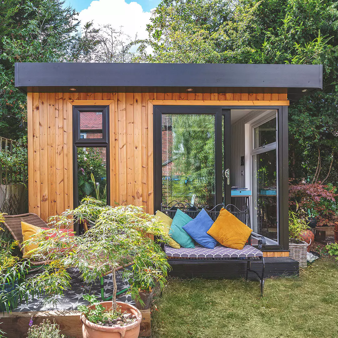 Small redwood garden room with outdoor seating & cushions