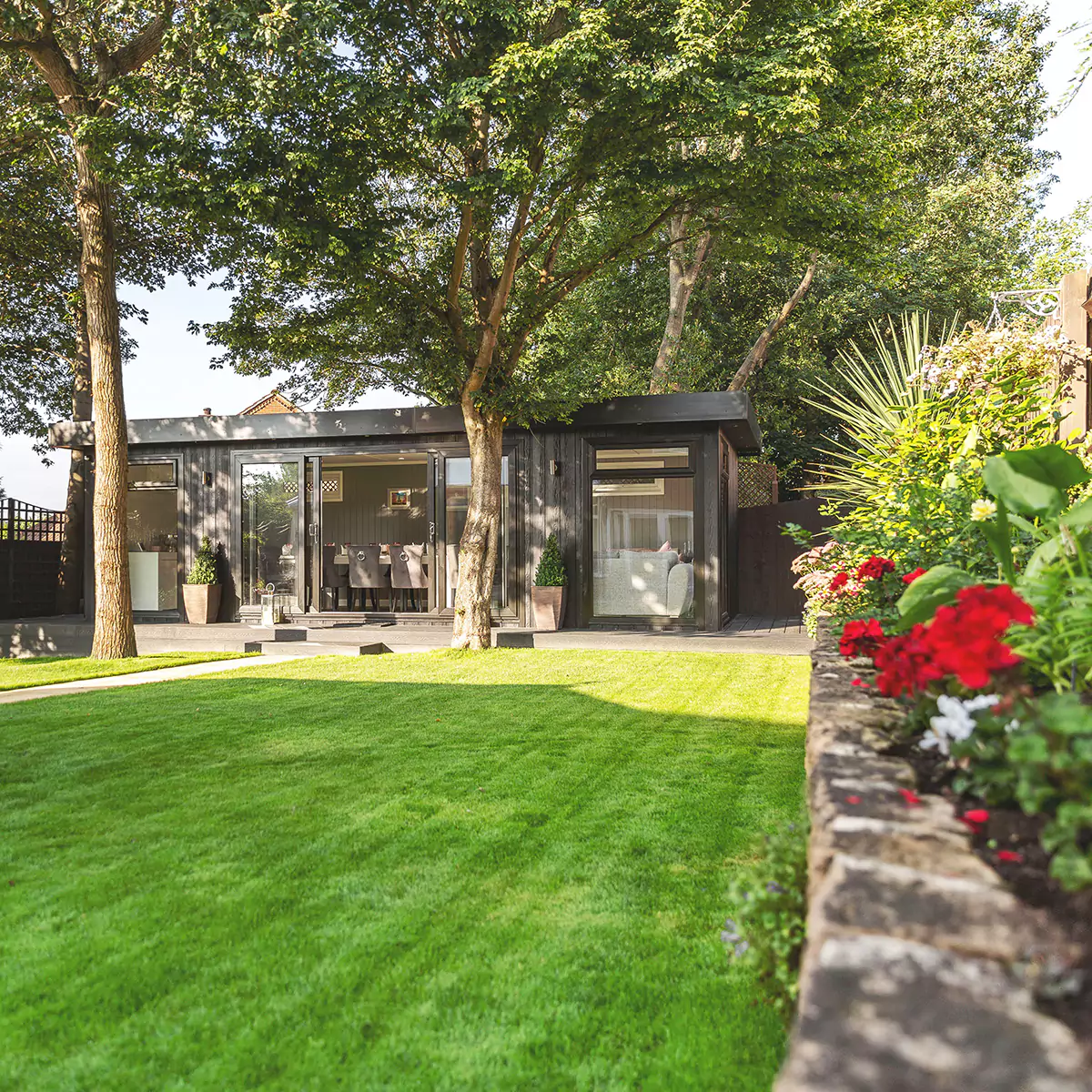 a garden dining room building with a green lawn and large trees in front of it