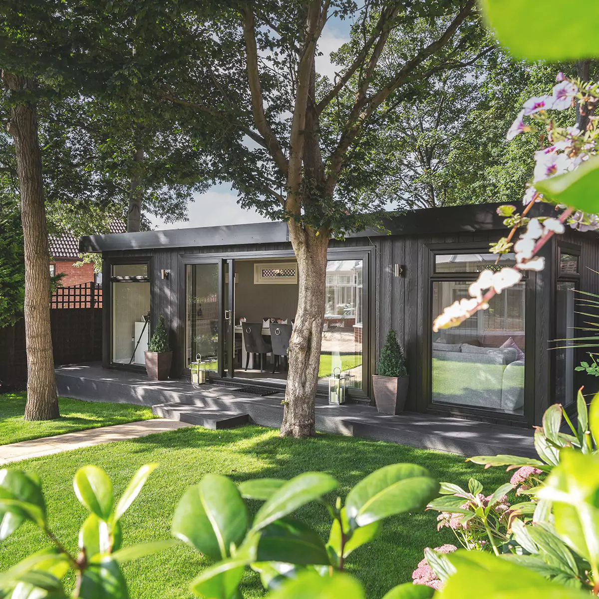 a garden dining room building with a green lawn and large trees in front of it