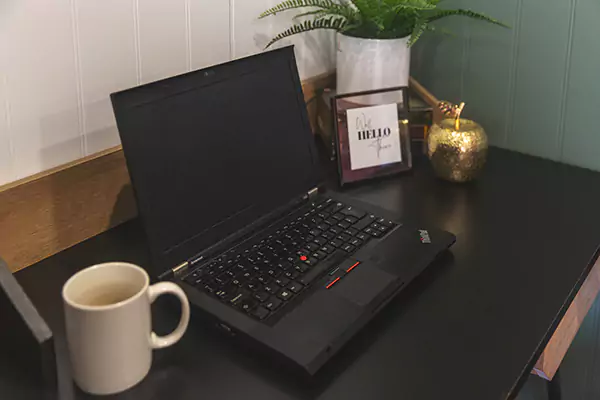 close up of home office desk with laptop & coffee mug