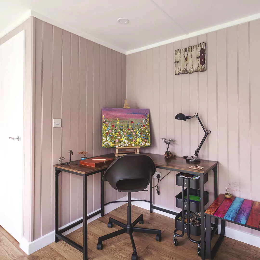 inside view of garden room with partition door and desk with chair and painting with colourful side table