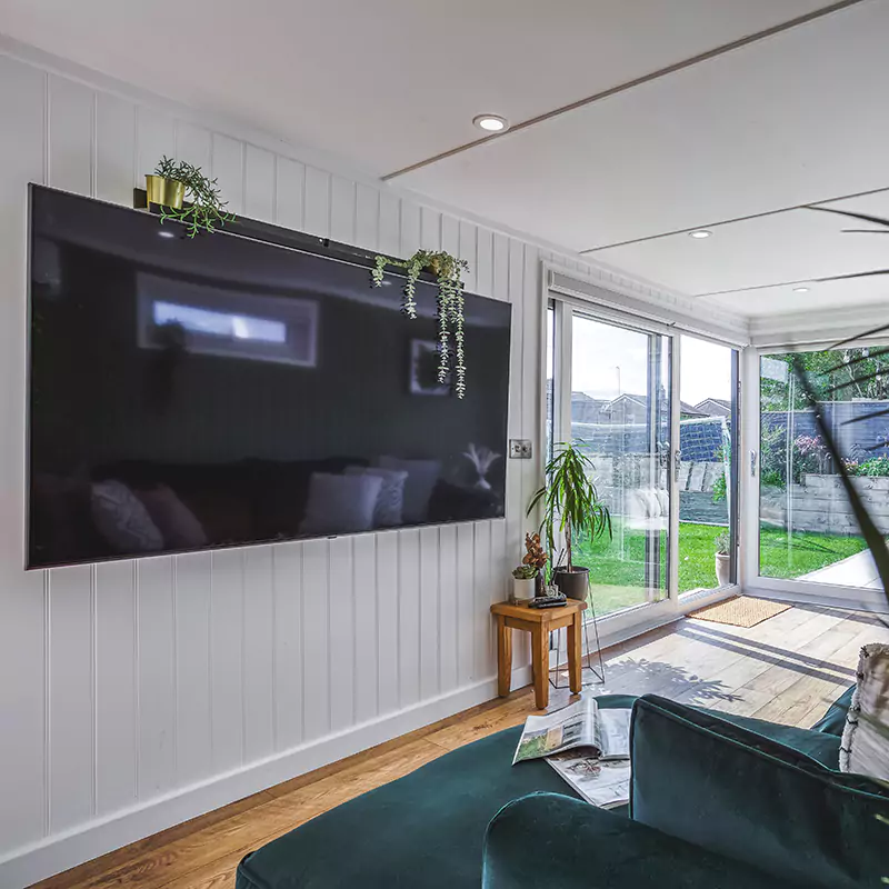 garden cinema room with large tv mounted on the wall