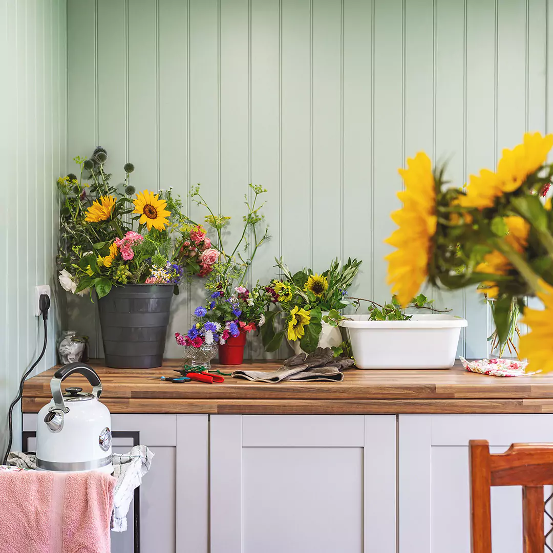 cabinet with assortment of flowers on top inside cabin master garden room with kettle