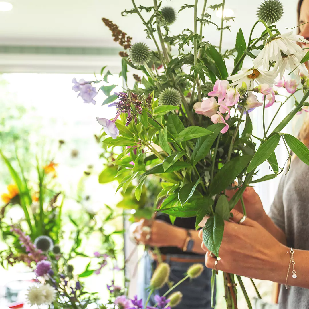 woman holding bouquet of flowers in garden room 