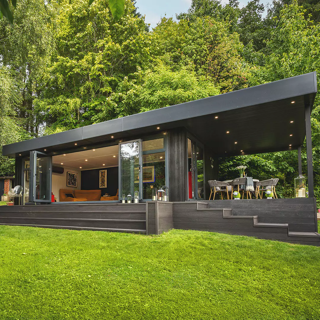 a black marley garden room with veranda and a timber deck with a covered patio