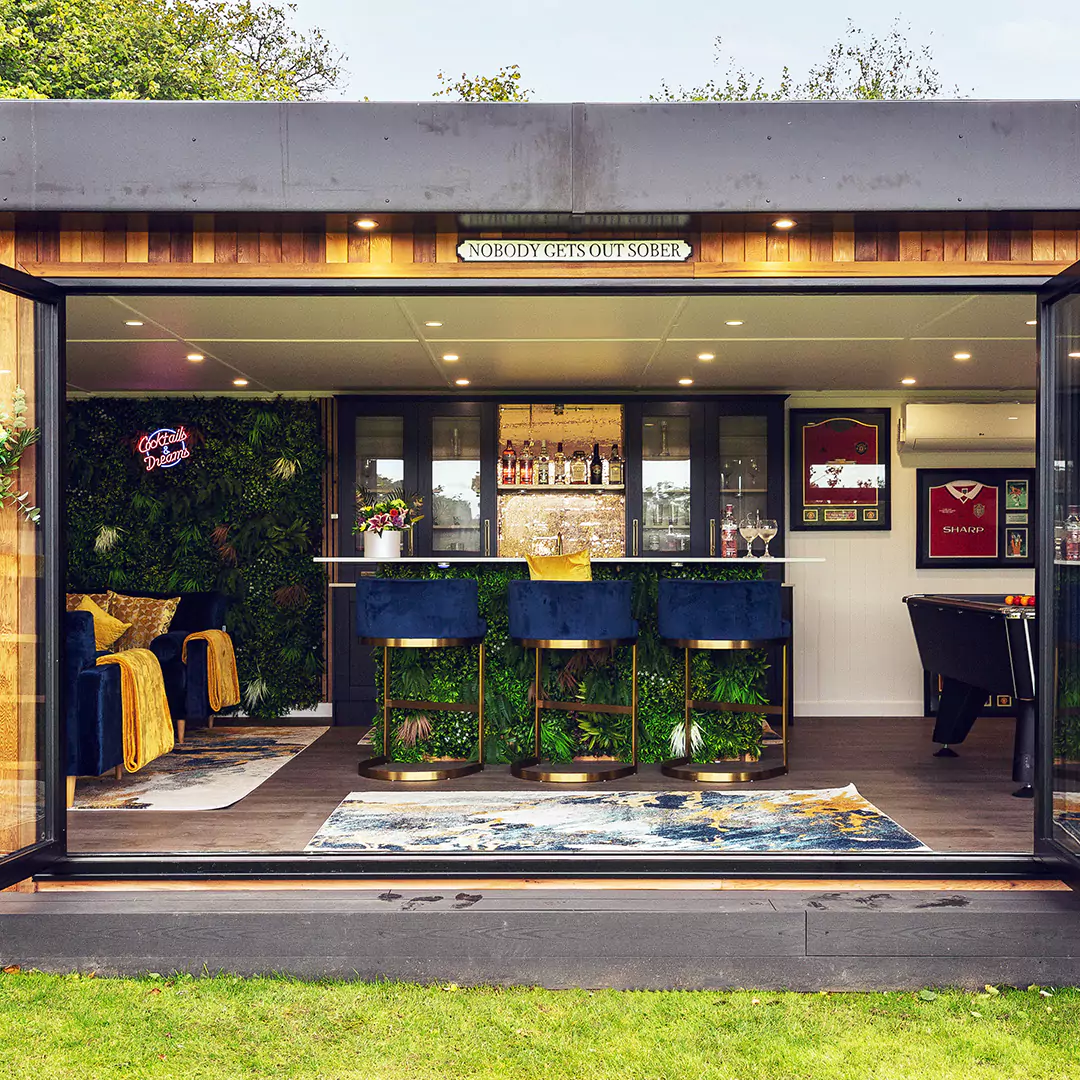 Looking into a luxury cedar timber garden bar with bar stools, faux plant walls and neon sign