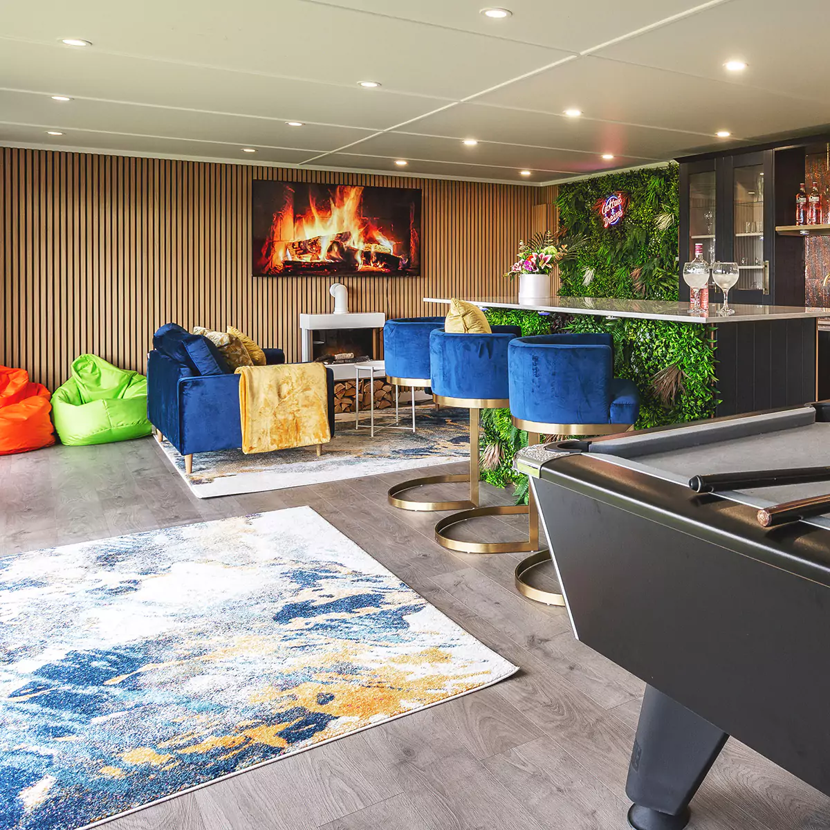 Interior of a garden room bar with bright decor, plant wall and neon sign