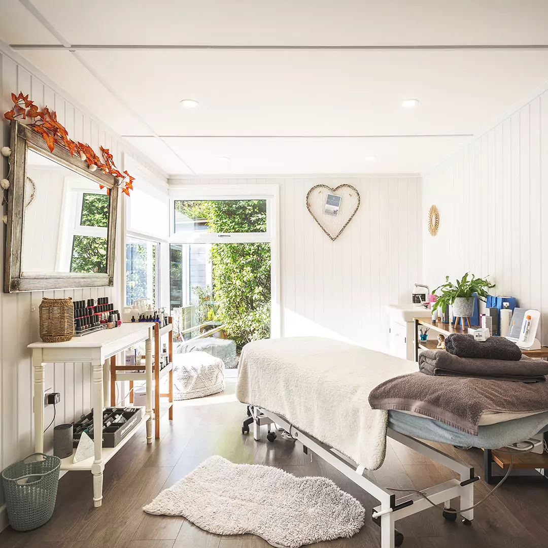 massage bed inside beauty room garden studio with a large mirror and furnishings 