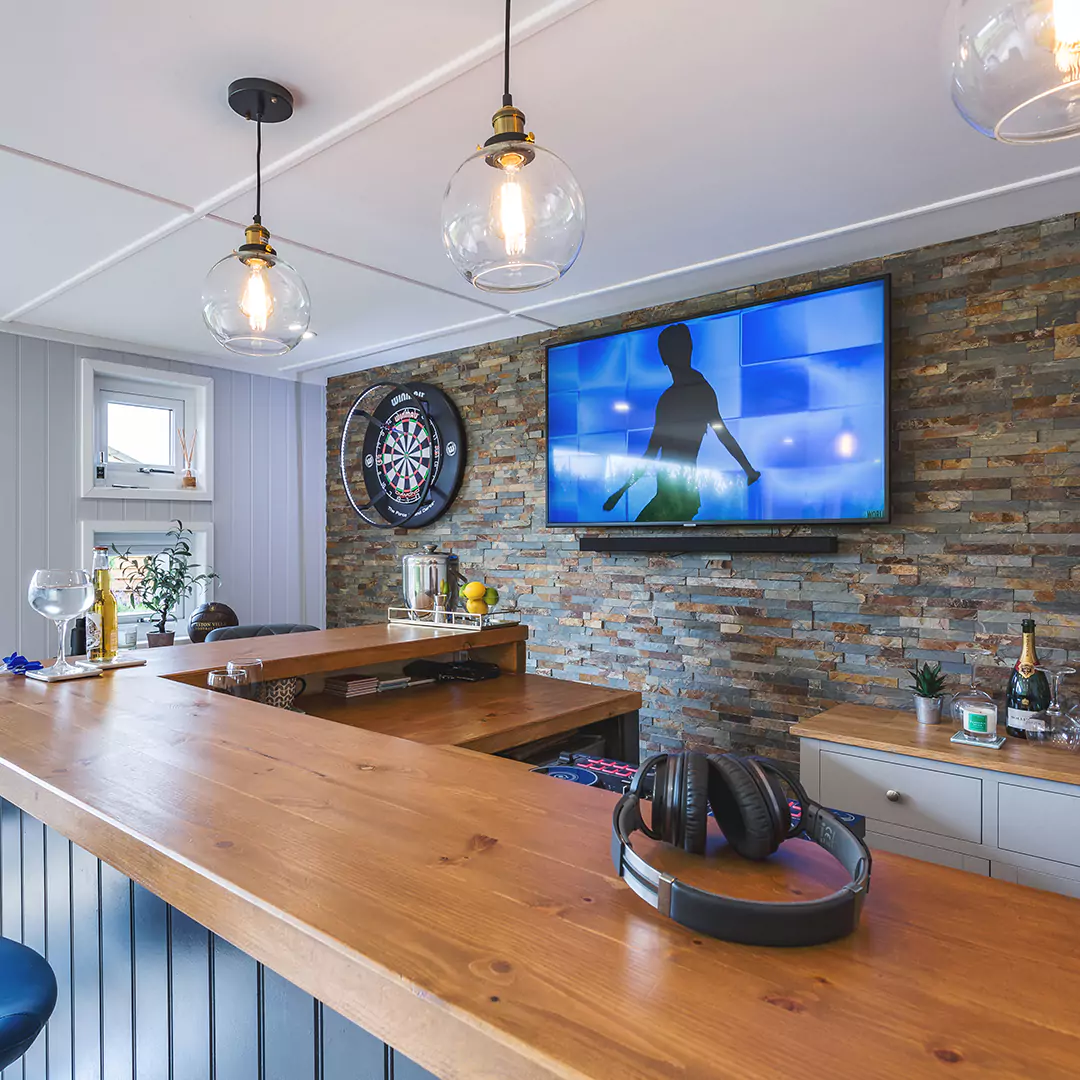 interior of a garden bar with pendant lights & dart board