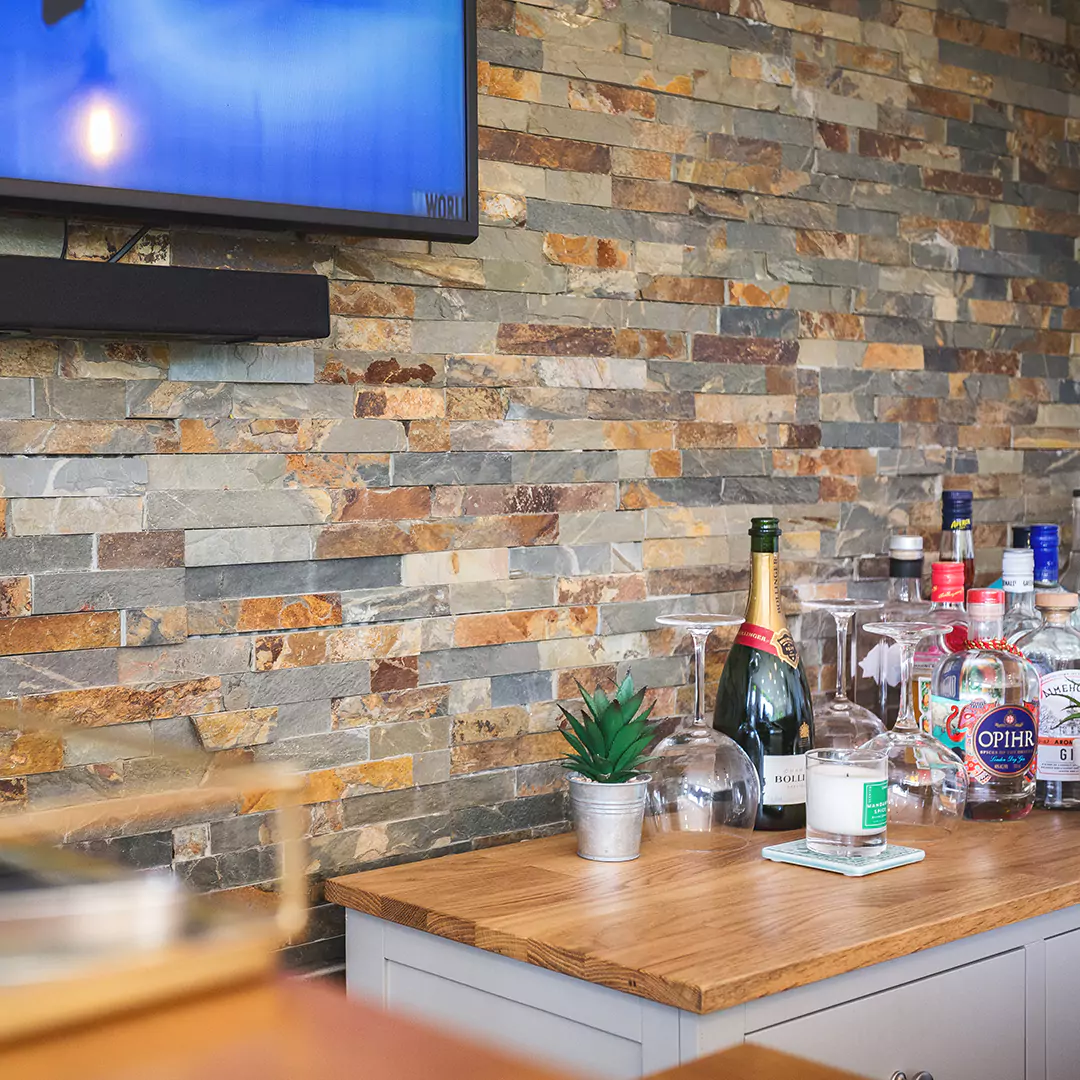 close up of man cave bar area with drinks & slate feature wall