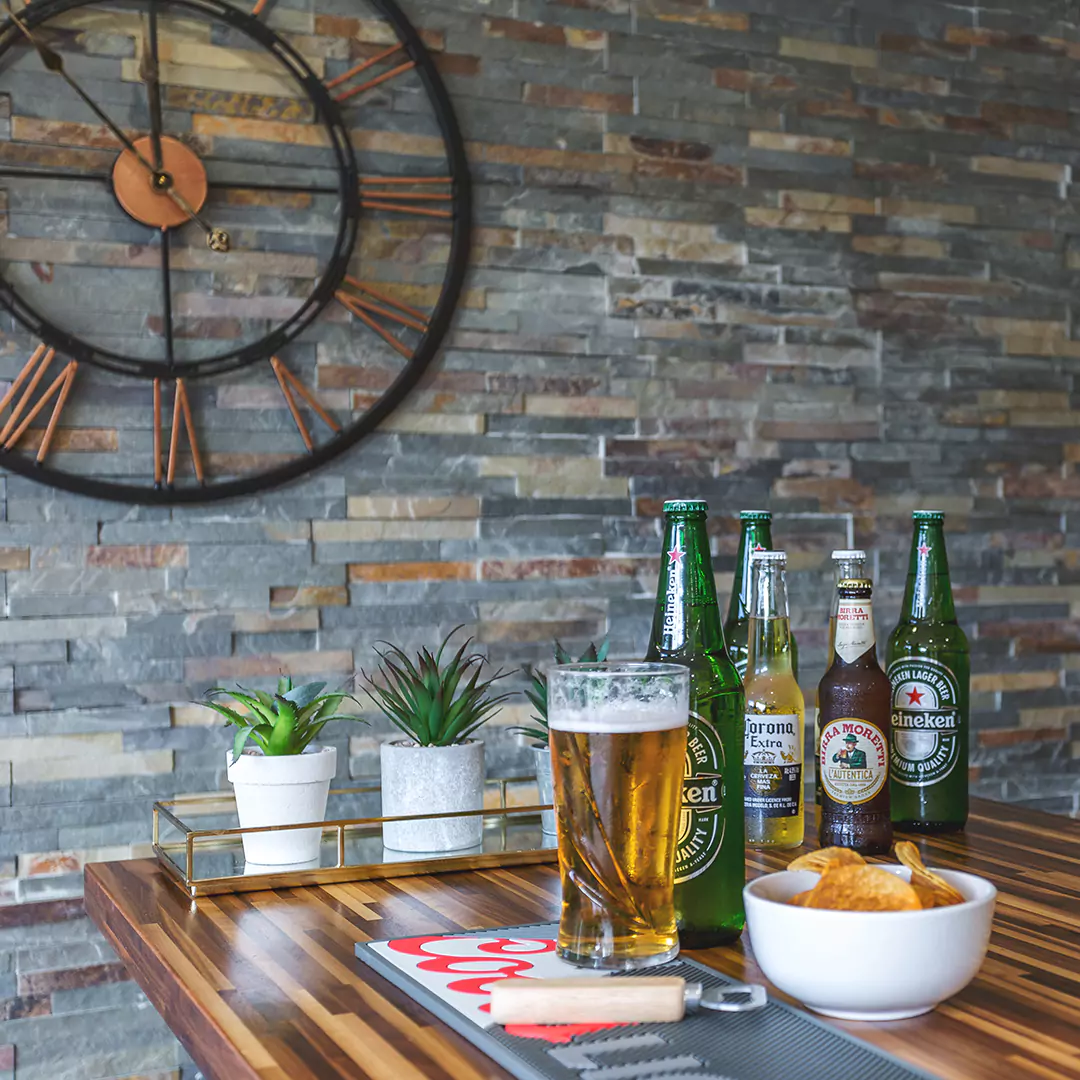 Interior of a garden bar with slate clad wall and drinks