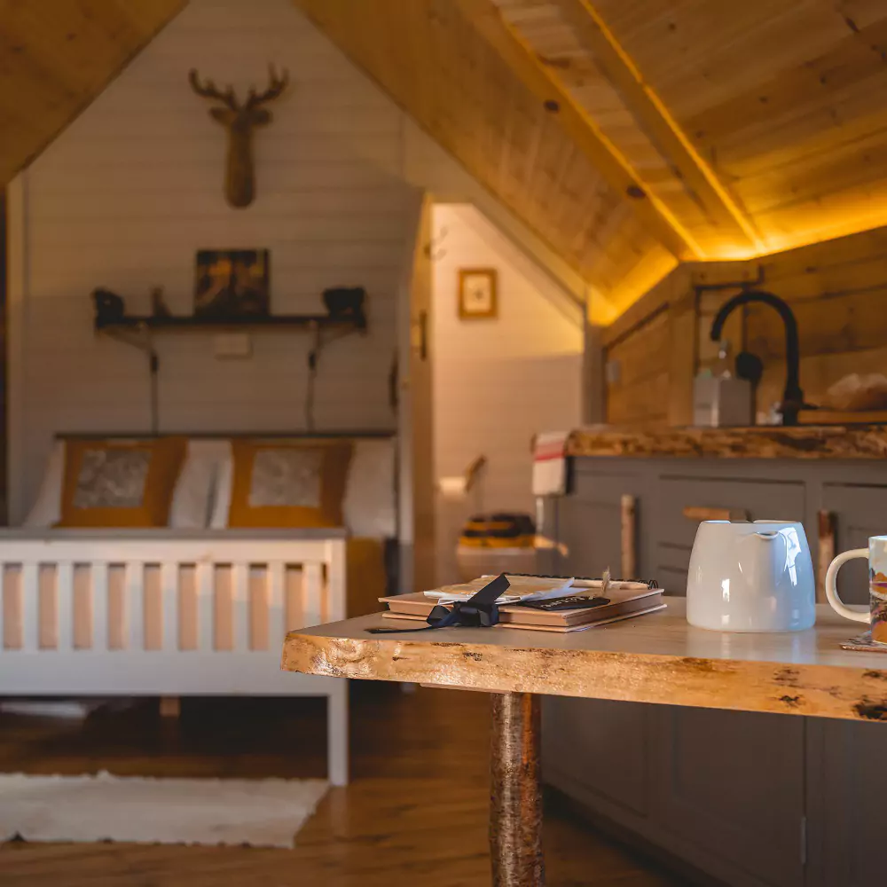 Kitchenette area within a luxury log camping cabin with dining area