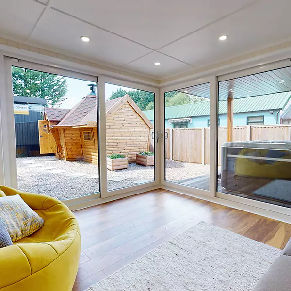 garden room with veranda and large yellow sofa with sliding glass doors and view of nottingham show site