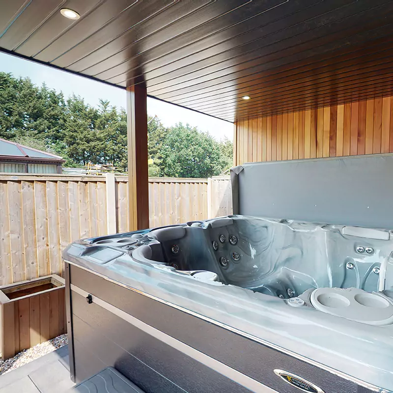 Hydropool midlands hot tub in Show Site Garden Room with Veranda with view of bench and arctic cabins