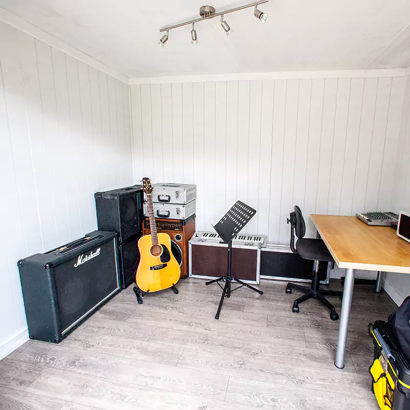garden music room with guitar and sheet stand and desk with speakers
