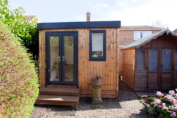small garden office with small window and french doors