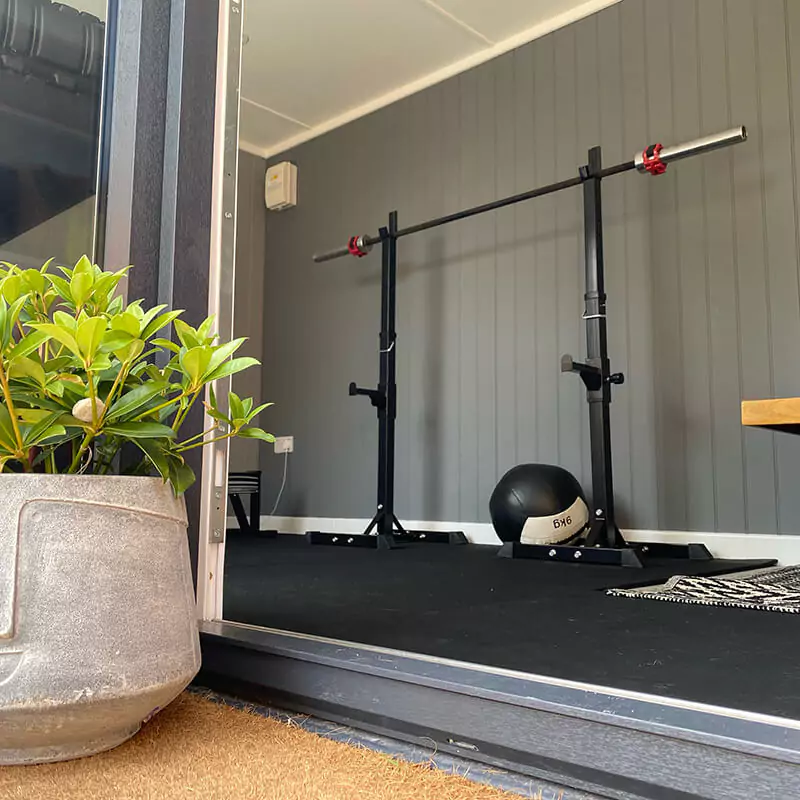 garden gym and office with row machine and dumbbells and weight rack