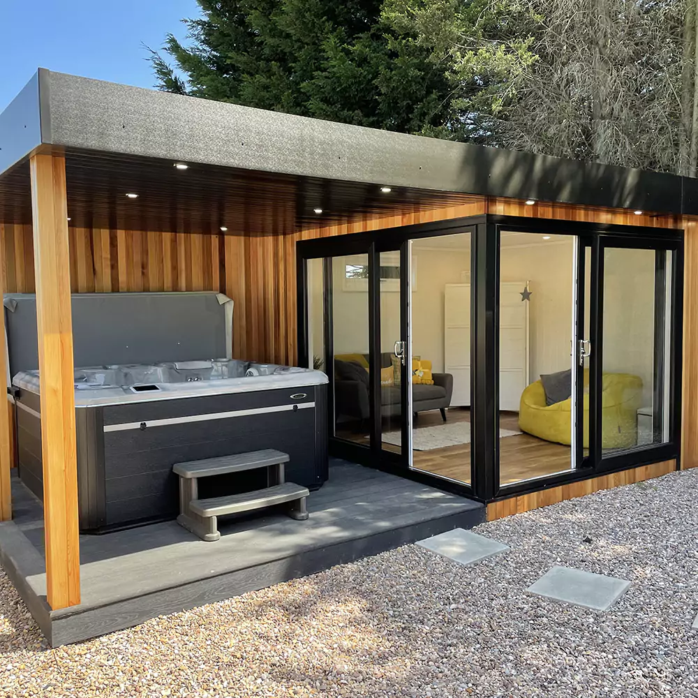 Show Site Veranda Room cedar Cladding garden building with veranda and hydropool midlands hot tub and view into building with grey and yellow home furnishings  