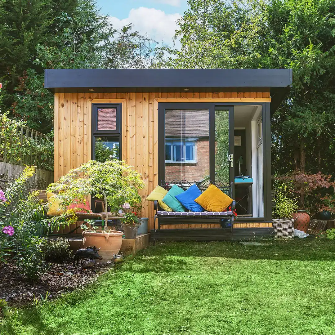 Small garden office with bright cushions on sofa outside