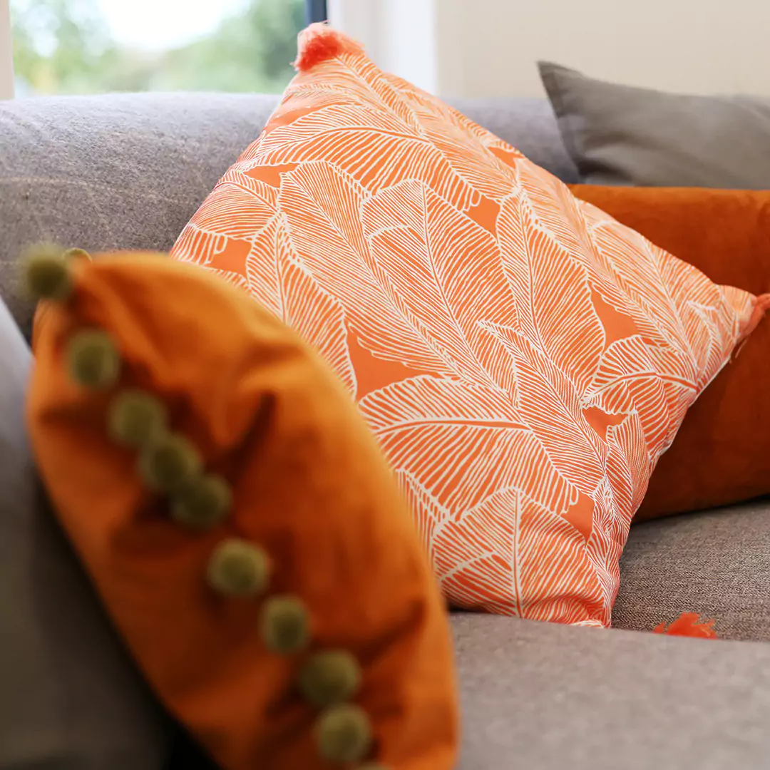 close up of rust coloured cushions on a sofa