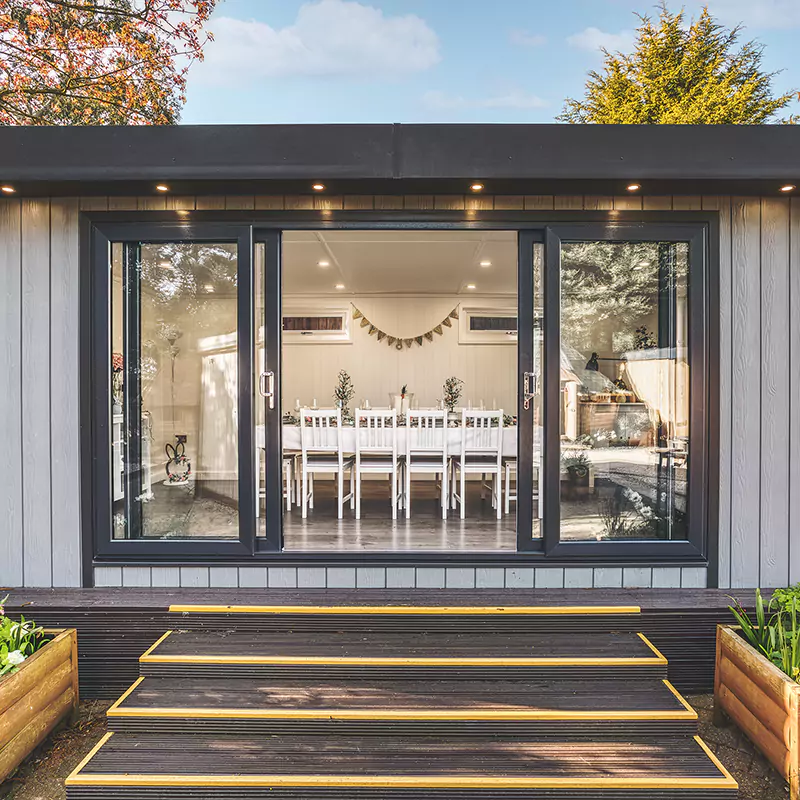 large garden dining room on nottingham show site with timber steps and large white dining table with chairs