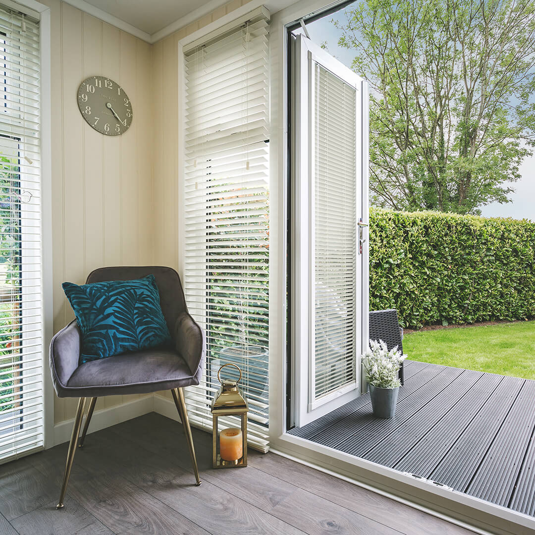 Cabin Master Cedar Summerhouse with Indoor Furnishings and view of lawn area with timber decking and open door