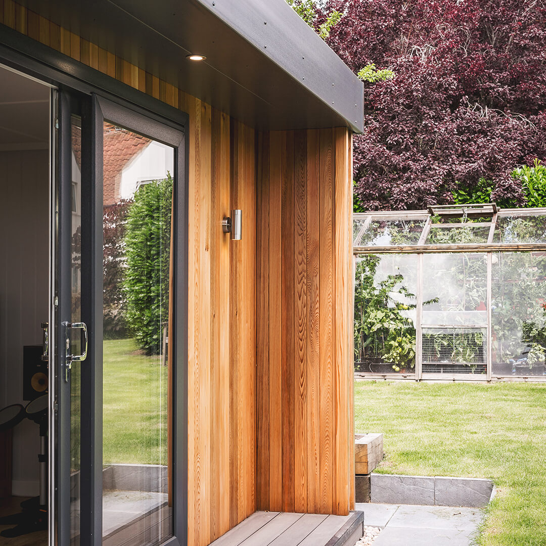 cedar garden building with view of large grass lawn area and patio area